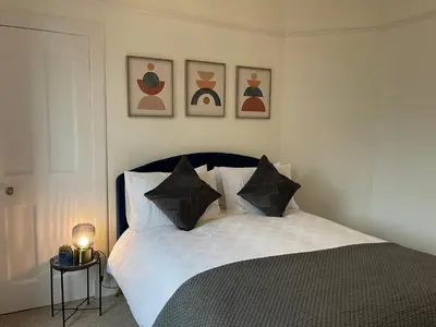 a bedroom with a bed with black and white pillows at A Shore Stay in Gourock