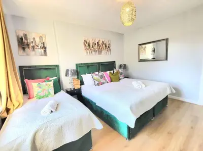 two beds sitting next to each other in a bedroom at 4 Bedrooms Apartment By Sensational Stay Short Lets & Serviced Accommodation in Edinburgh