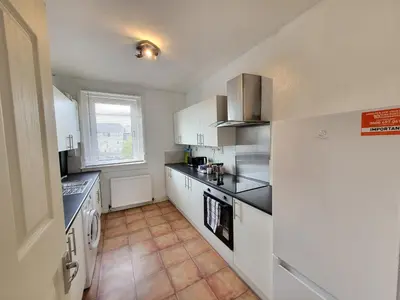 a kitchen with white cabinets and a refrigerator at 4 Bedrooms Apartment By Sensational Stay Short Lets & Serviced Accommodation in Edinburgh