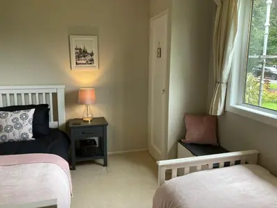 a bedroom with two beds and a window at Cedar Lodge in Oban