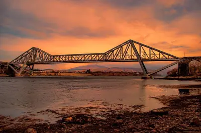 a bridge over a river with a cloudy sky at Cedar Lodge in Oban