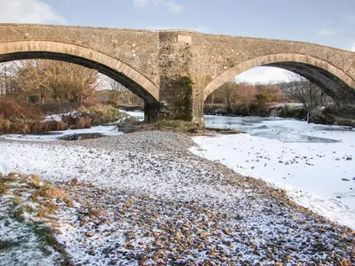 an old bridge over a river in the snow at Fiddlers Rest in Ballantrae