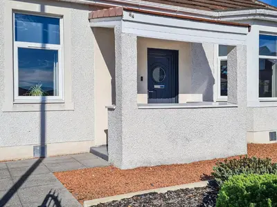 a house with a black door on the side of it at Kirklea in Wishaw