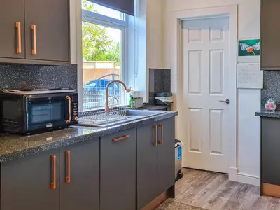 a kitchen with a sink and a microwave at Kirklea in Wishaw