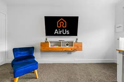 a blue chair and a sign on a wall at One Bed Holiday Home in the Heart of Glasgow in Glasgow