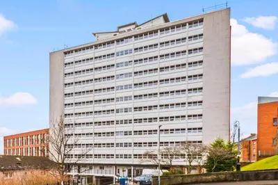 a large white office building in a city at One Bed Holiday Home in the Heart of Glasgow in Glasgow
