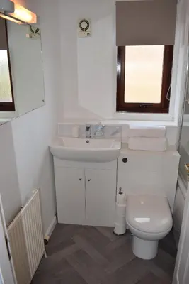 a white bathroom with a sink and a toilet at Kelpies Serviced Apartments- McLaughlan in Falkirk