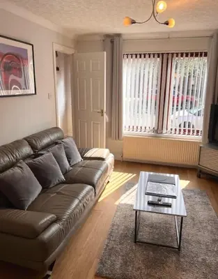 a living room with a leather couch and a coffee table at Kelpies Serviced Apartments- McLaughlan in Falkirk
