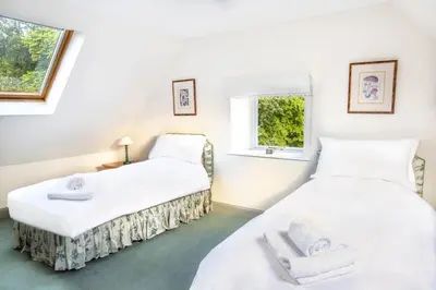 two twin beds in a room with a window at The Stables in Castle Douglas