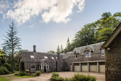 an exterior view of a large brick house with a garage at The Stables in Castle Douglas
