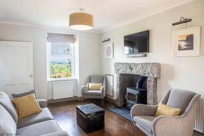 a living room with a couch and a fireplace at Culdoach in Castle Douglas