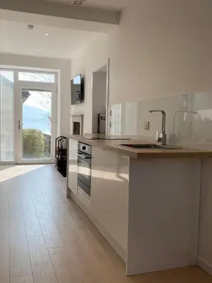 a kitchen with white appliances and a large window at Hugmish in Tighnabruaich