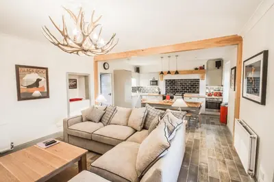 a living room with a couch and a table at Diamonds Laggan in Castle Douglas