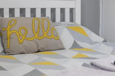 a bed with a pillow with the word hello on it at 1 bed apartment central Hamilton free wifi with great transport links to Glasgow in Hamilton