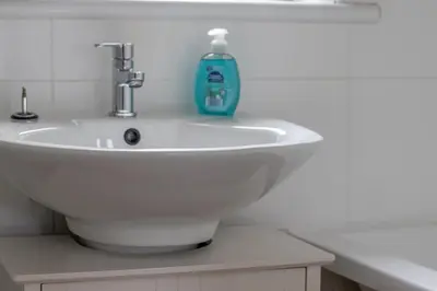 a white sink with a blue soap bottle on it at 1 bed apartment central Hamilton free wifi with great transport links to Glasgow in Hamilton