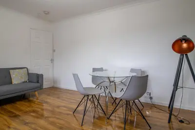 a living room with a table and chairs and a couch at 1 bed apartment central Hamilton free wifi with great transport links to Glasgow in Hamilton
