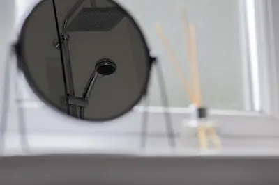 a mirror on a wall in a bathroom at 1 bed apartment central Hamilton free wifi with great transport links to Glasgow in Hamilton