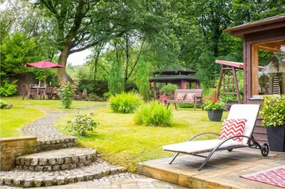 a garden with a bench and a gazebo at Stunning 4-Bedroom Country House with Hot Tub & Sauna near Loch Lomond in Glasgow