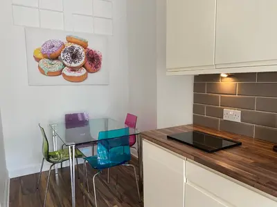 a kitchen with a glass table with donuts on the wall at Lovely main door 2 bed apartment in Edinburgh