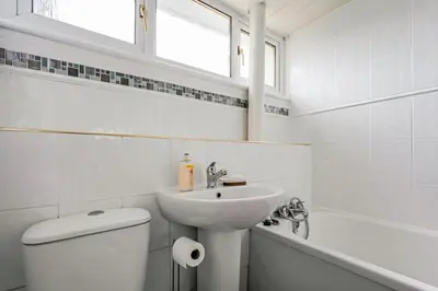 a white bathroom with a sink and a toilet at Centrally Situated 1 Bedroom House in Cumbernauld in Cumbernauld