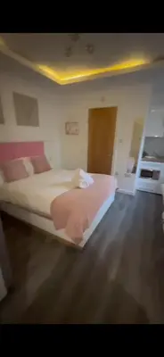 a bedroom with a bed with pink sheets on it at Crosskeys Edinburgh in Edinburgh