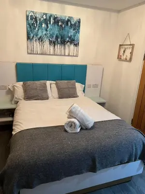 a bed with a cat laying on top of it at Crosskeys Edinburgh in Edinburgh
