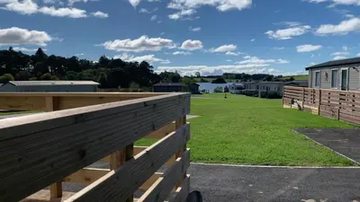 a fence with a field in the background at HV66 - FREE WIFI-3 Bedrooms Indoor Pool Loch Views Fishing Golf Riding Shooting Water Sports 15 Mins Drive To Beaches PASSES NOT INCLUDED Most Activities Will Not Be Available Out Of Season Please Check Before Booking in Newton Stewart