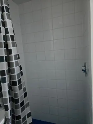 a bathroom with a shower with a black and white shower curtain at The Waterfront in Greenock