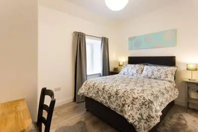 a bedroom with a bed and a table and a window at Ideal Couples base for exploring the Isle of Arran in Shiskine