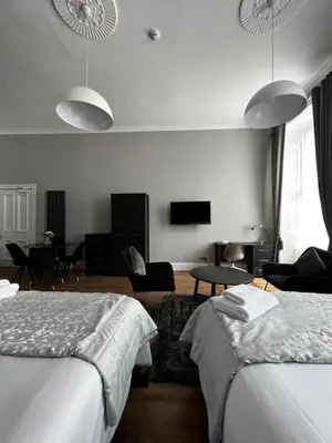 a hotel room with two beds and a tv at Amani Apartments - Glasgow City Centre in Glasgow
