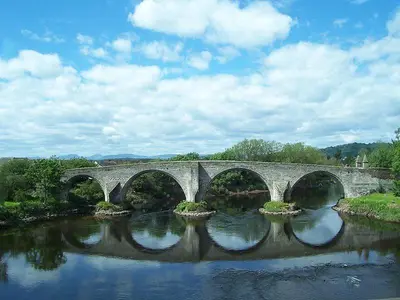 a bridge over a river with four arches at Garden Cottage in Gargunnock
