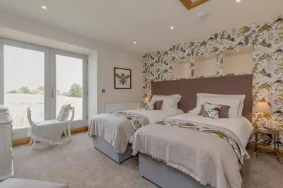 a bedroom with two beds and a window at Rachel's Farm luxury escapes with Hots Tubs in Buchlyvie