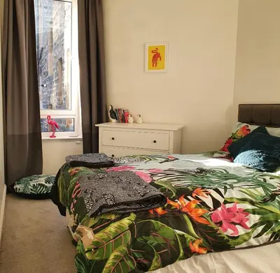 a bedroom with two beds and a window at The Flat with the Pink Door in Edinburgh
