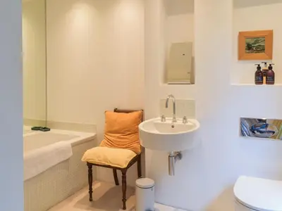a white bathroom with a sink and a toilet at Tigh Nam Muc in Loanhead