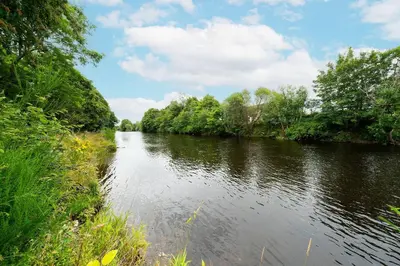 a river with trees on the side of it at Earnside Cottage in Comrie