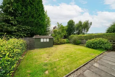 a yard with a fence and a small shed at Earnside Cottage in Comrie