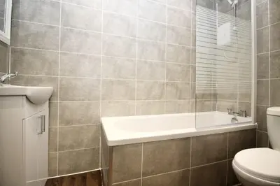 a bathroom with a tub and a toilet and a sink at Katie's house in Cumbernauld