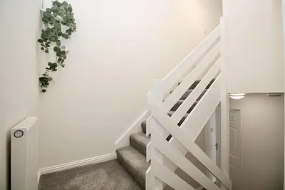 a white staircase in a house with white walls at Katie's house in Cumbernauld