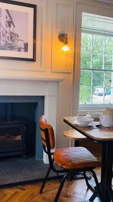 a dining room with a table and a fireplace at Custom House Hotel in Bowling