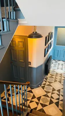 a hallway with a staircase with a door and a tiled floor at Custom House Hotel in Bowling