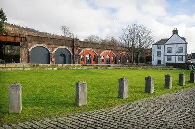 a group of posts in the grass in front of a building at Custom House Hotel in Bowling