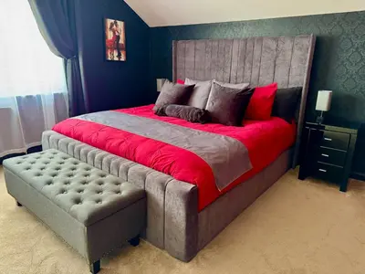 a bedroom with a large bed with a red blanket at FINN VILLAGE Loch Lomond Villa - THE BLACK ROOM with Private Jacuzzi-Style Bath in Drymen