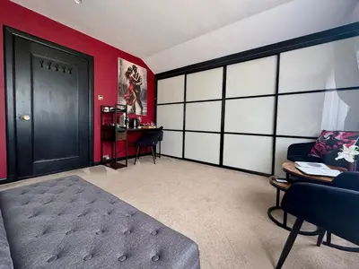 a bedroom with a black door and a red wall at FINN VILLAGE Loch Lomond Villa - THE BLACK ROOM with Private Jacuzzi-Style Bath in Drymen