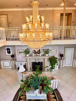a large room with a chandelier and a fireplace at FINN VILLAGE Loch Lomond Villa - THE BLACK ROOM with Private Jacuzzi-Style Bath in Drymen
