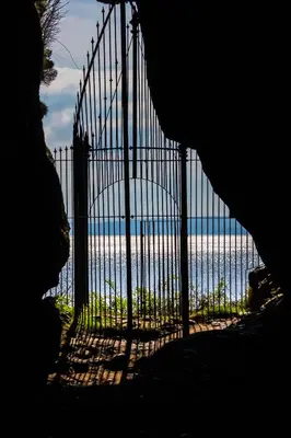 a gate with a view of the ocean behind it at Kings Caves Glamping in Torbeg