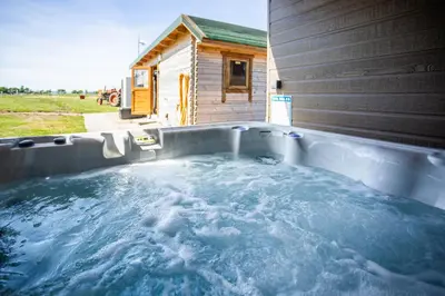 a hot tub in front of a house at Kings Caves Glamping in Torbeg
