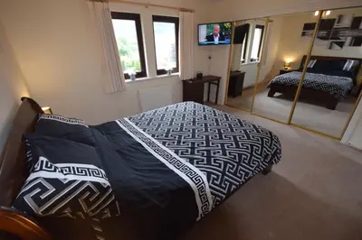 a bedroom with a bed and a mirror at Ridgeview Villa - Partial loch view in Lochgoilhead