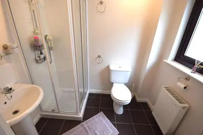 a bathroom with a shower and a toilet and a sink at Ridgeview Villa - Partial loch view in Lochgoilhead