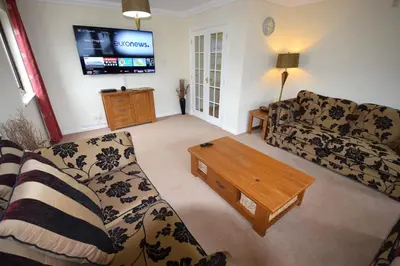 a living room with a couch and a coffee table at Ridgeview Villa - Partial loch view in Lochgoilhead