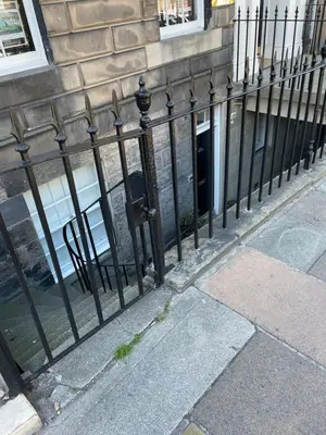 a black fence in front of a building at Super central Edinburgh Castle basement in Edinburgh